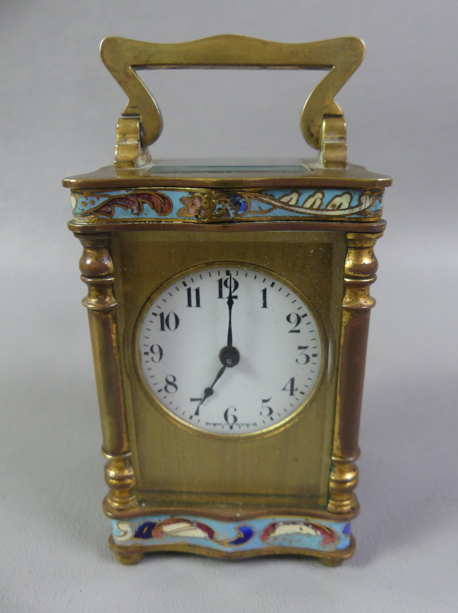 FRENCH CHAMPLEVE CARRIAGE CLOCK: Small antique French brass, beveled glass and champleve enamel carriage clock. Has brass movement with 1.25 in enamel dial signed Made in France. Appears to be running when wound. 3 x 2 x 1.75 inches