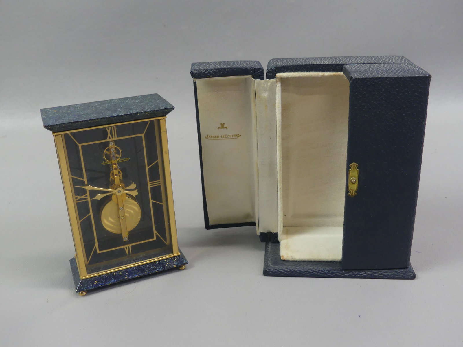 JAEGER LECOULTRE LAPIS DESK CLOCK: Fine old Swiss manual-wind desk clock in brass and lapis lazuli signed Jaeger LeCoultre #481 circa 1970. Has original box with hinged doors. Clock is 4.5 in tall x 3 x 1.5 in. Fine condition, working.