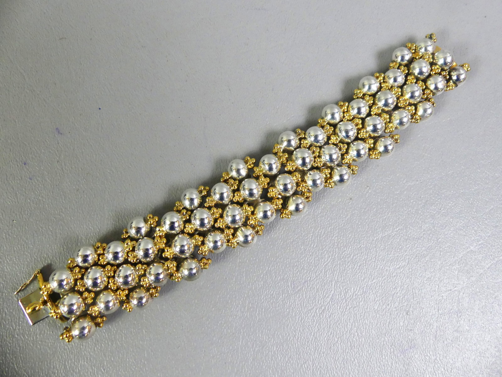 HEAVY MEXICAN STERLING BRACELET: Heavy sterling silver Mexican bracelet, one inch wide and 7 inches long. It has rows of beads with smaller gilt beading. Weighs 4.44 ozt.