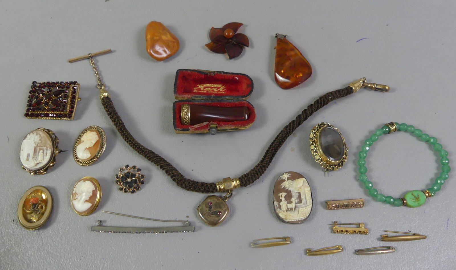 LOT VICTORIAN JEWELRY & CAMEOS: Lot of Victorian jewelry: 12 in woven hair mourning watch fob with locket; cigarette holder in case; 4 cameos; garnet brooch; jade bracelet; 2 Baltic amber pendants, etc.
