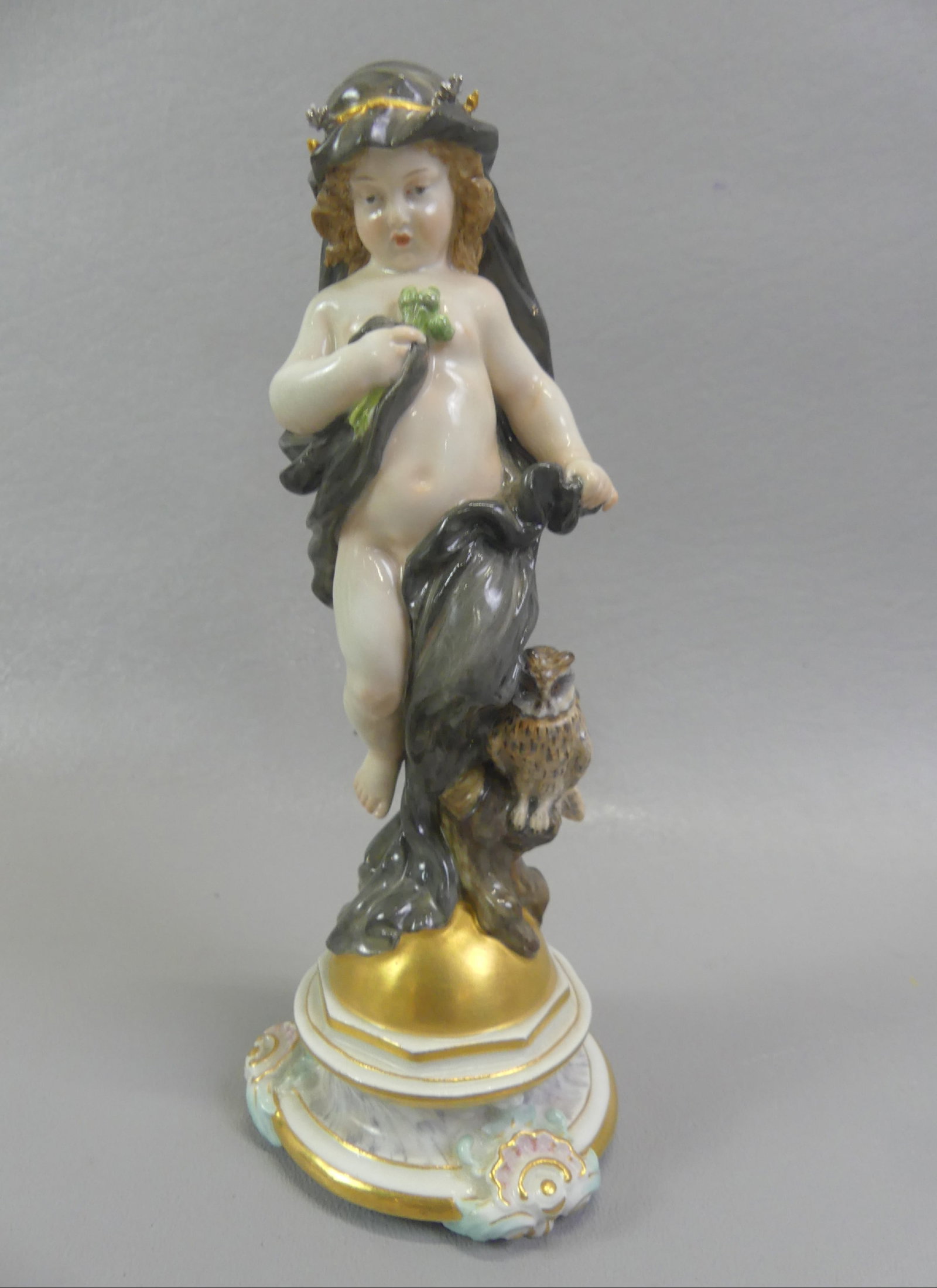 MEISSEN FIGURINE OF CHERUB & OWL: 19th century Meissen porcelain figurine of a cherub with long cape standing on golden orb with owl at her feet. Has blue underglaze crossed swords mark. 7 in tall, excellent condition.