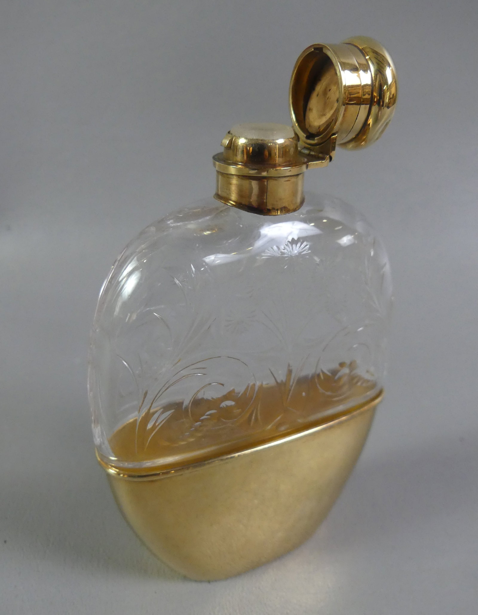 TIFFANY & CO 14K GOLD & GLASS FLASK: Rare 14k gold and floral engraved glass flask, stamped on the underside of removable base 1 GILL, Tiffany & Co, 14K with numbers. Size: 5 in tall x 3.5 x 1 in thick. Base weighs 50.4 grams or 32.45