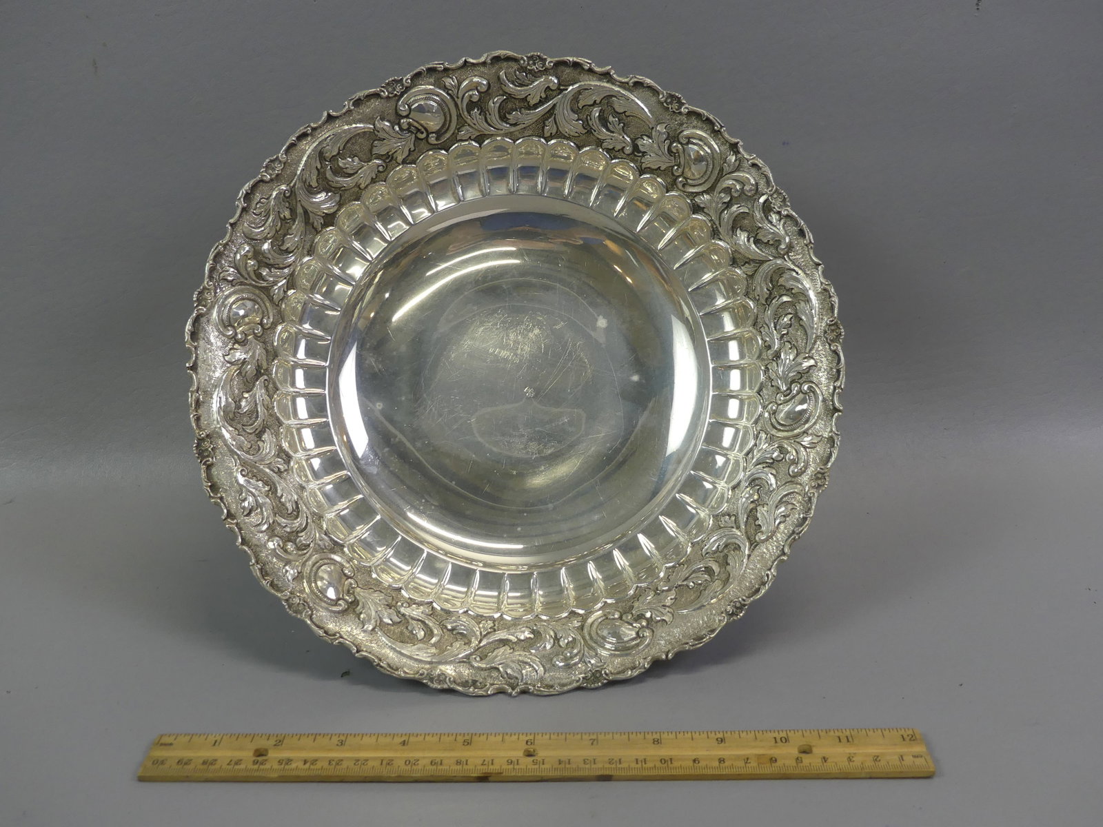 STERLING SILVER REPOUSSE BOWL: Sterling silver footed repousse bowl with arabesque designs, 11.5 x 4.5 inches (slight tilt). Weighs 22.13 ozt.