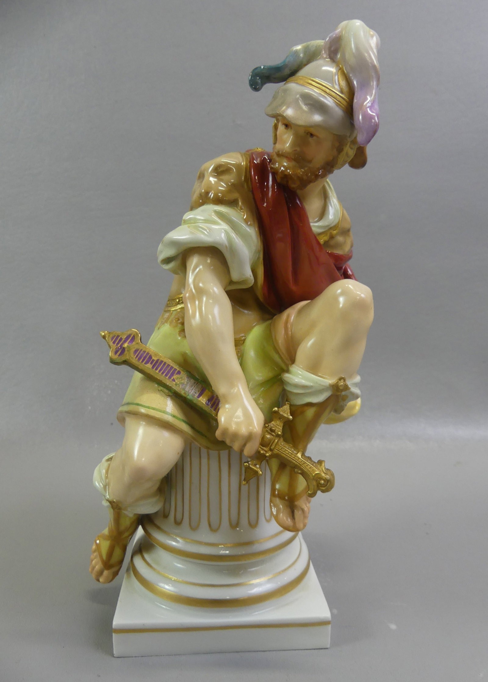 KPM PORCELAIN FIGURE - ROMAN SOLDIER: Large 19th century KPM (Royal Porcelain Factory of Berlin) figure of a seated Roman soldier holding a sword. Has blue underglaze scepter mark. 10 in tall and 4 in wide. Good condition with professiona
