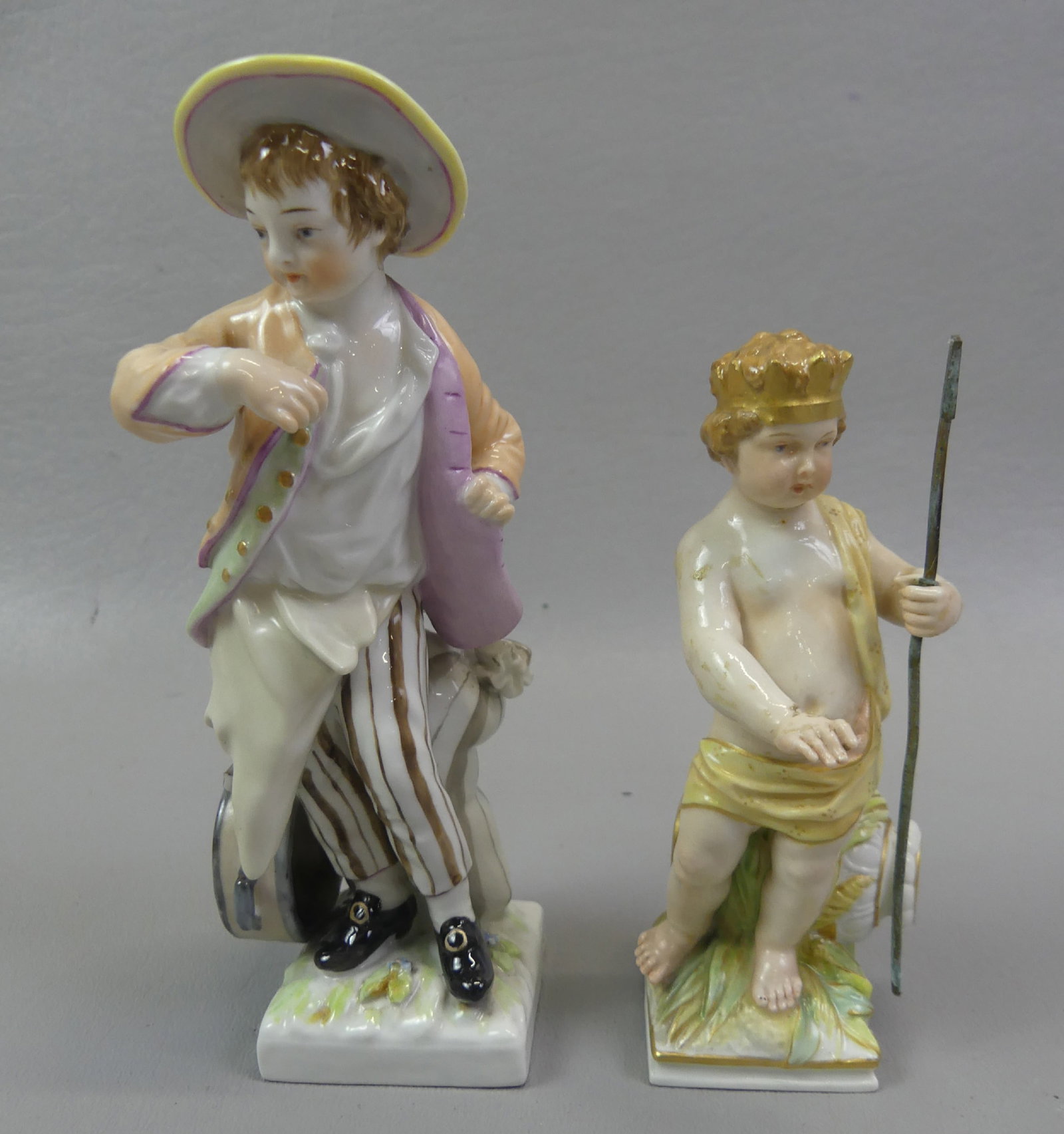 2 KPM FIGURINES: BOY & BABY NEPTUNE: Lot of two 19th century KPM (Royal Porcelain Factory of Berlin) figurines: baby Neptune holding trident (repair to thumb), 4.75 in; and boy with drum, 5.75 in (chip).