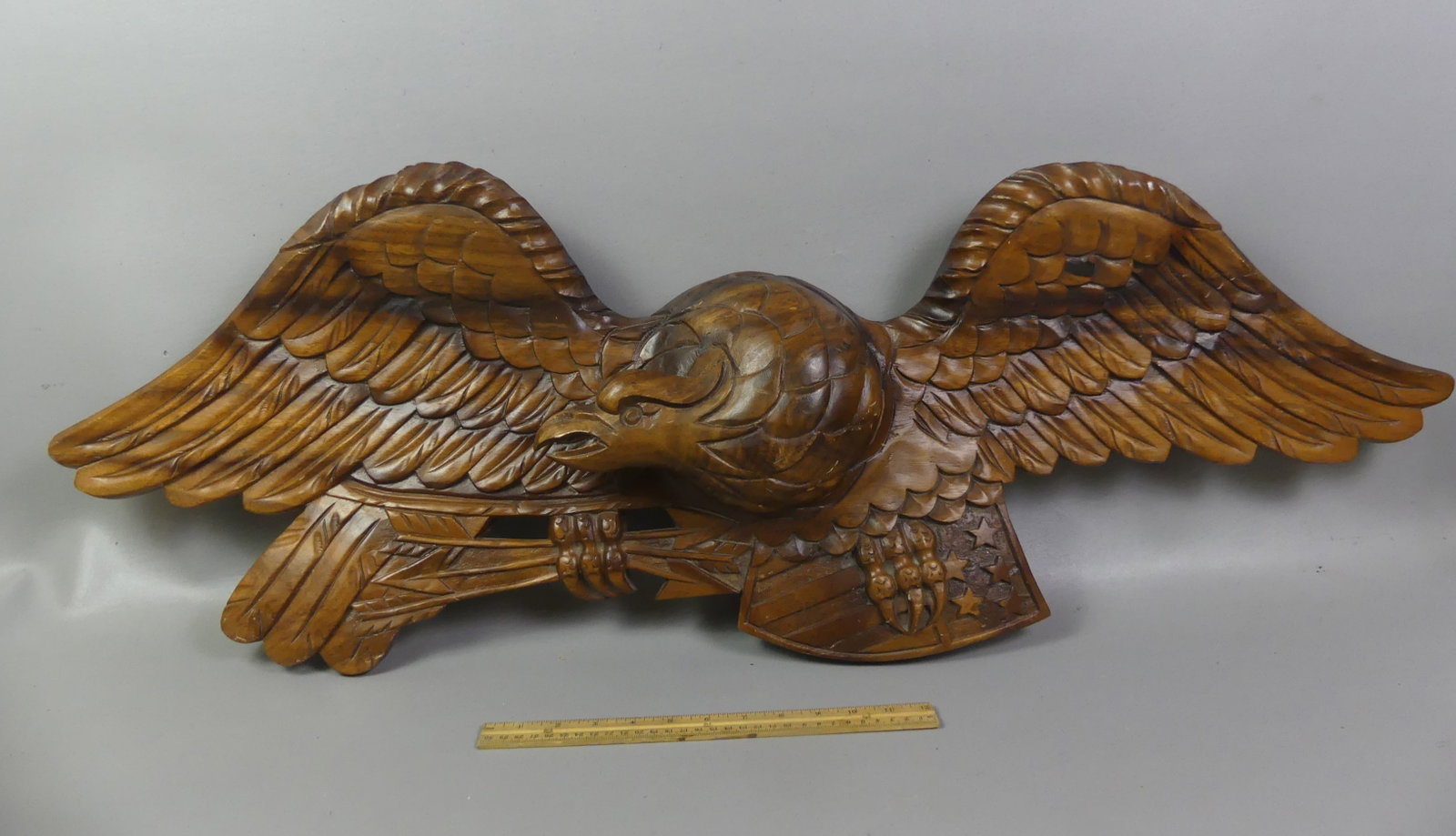 CARVED WOOD EAGLE PLAQUE: Large vintage carved and stained wood American eagle plaque, unsigned. 43 in long x 14 h x 4 in thick.