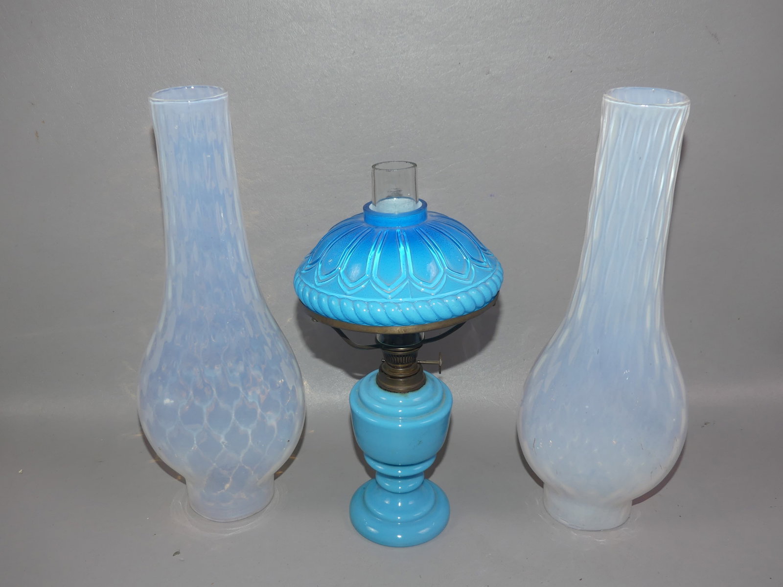 LOT ART GLASS LAMPS & CHIMNEYS: Lot of 5 art glass lighting items: Pair of opalescent peg lamps with applied rosettes and oil burners, 6 in diameter; pair of opalescent ovoid chimneys in diamond quilt design, 11.75 in tall; and 9.5 