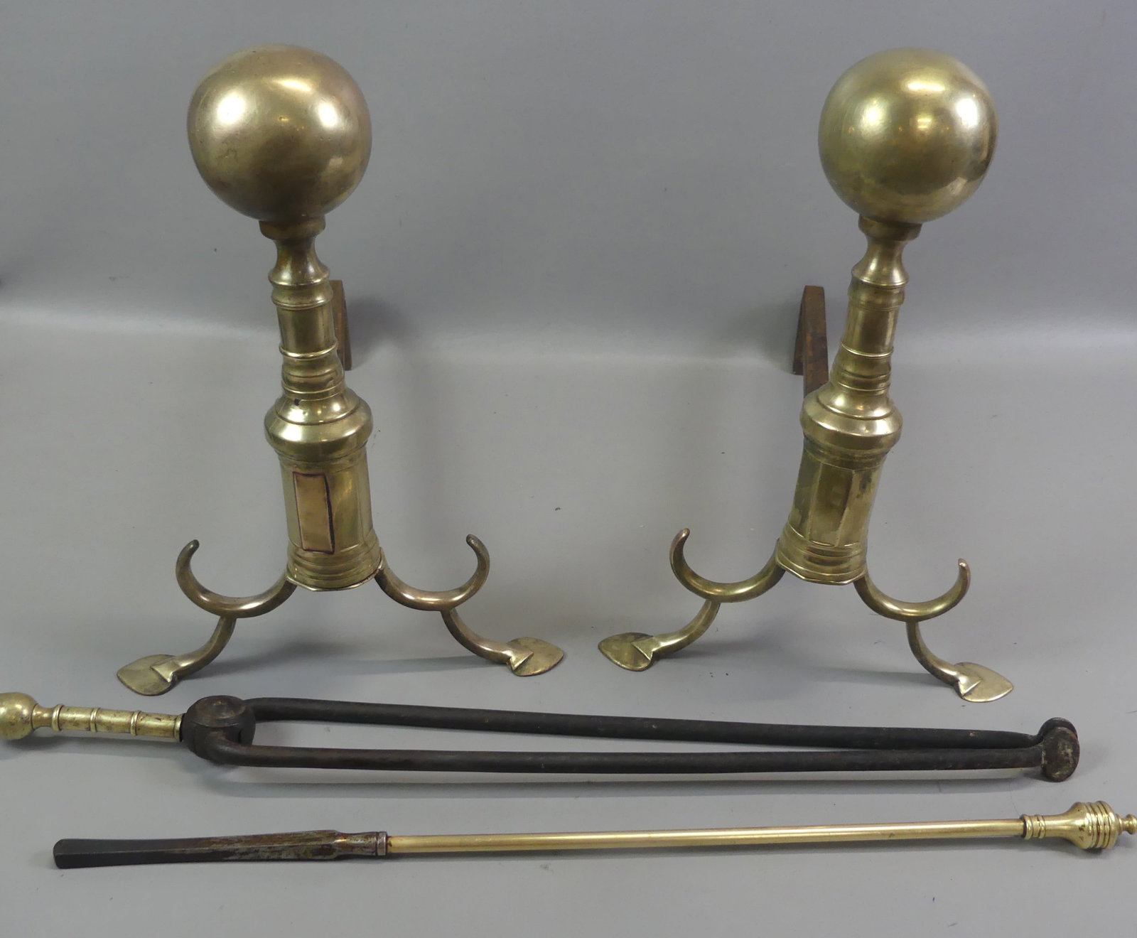 PHILADELPHIA PERIOD BRASS ANDIRONS: Pair of 18th century Philadelphia spade foot andirons with ball tops and spurs. 16.5 in tall and 12 in wide. Comes with 2 fireplace tools.