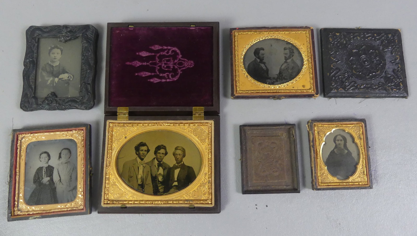 5 ANTIQUE PHOTOGRAPHS IN CASES: Lot of five 19th century photographs (4 ambrotypes and tintype) each mounted in leather or thermoplastic cases. Largest is an oval of 3 young men in Union case, 3.25 x 4.25 in; tintype of an Asian
