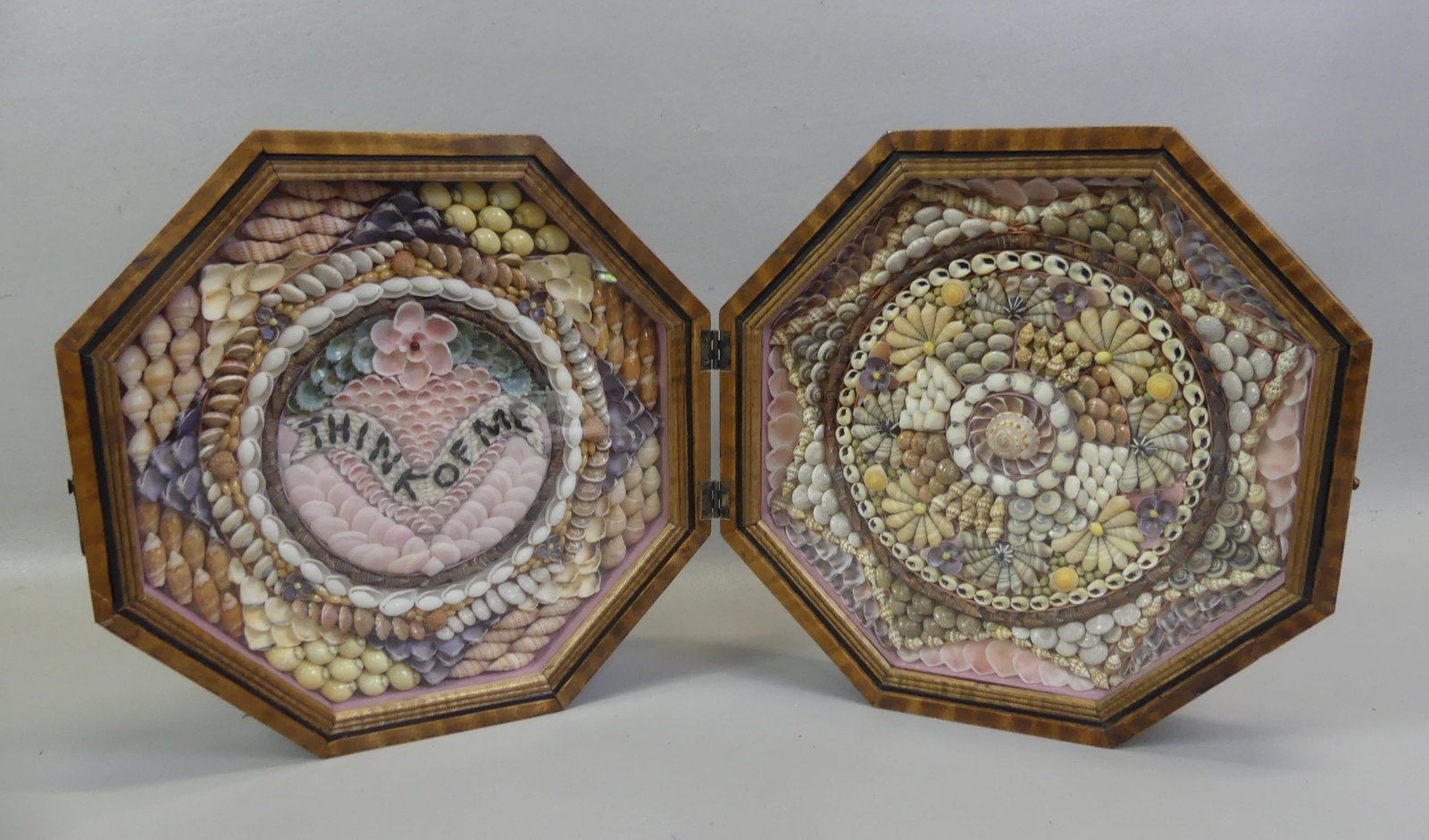 DOUBLE SEASHELL VALENTINE - THINK OF ME: Octagonal double seashell valentine in hinged striped walnut case. One side has notation --THINK OF ME. Has Barbados label verso. 11 in diameter. VG condition.