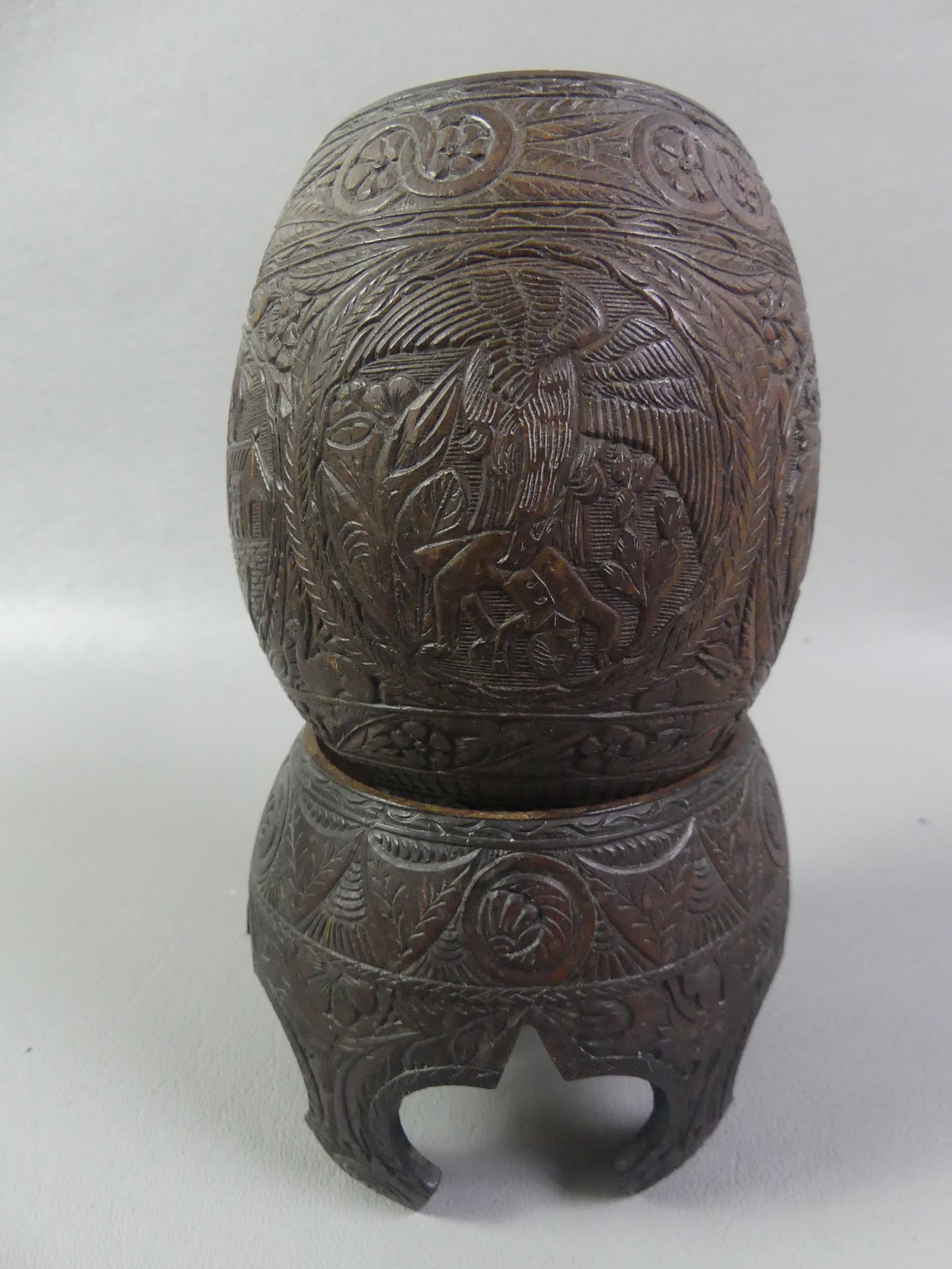 SAILOR MADE COCONUT CUP ON STAND: 19th century fine sailor made coconut cup on stand, hand carved with medallions of animals, scenics, and flowers. Overall heigh is 6.5 in tall. VG condition.