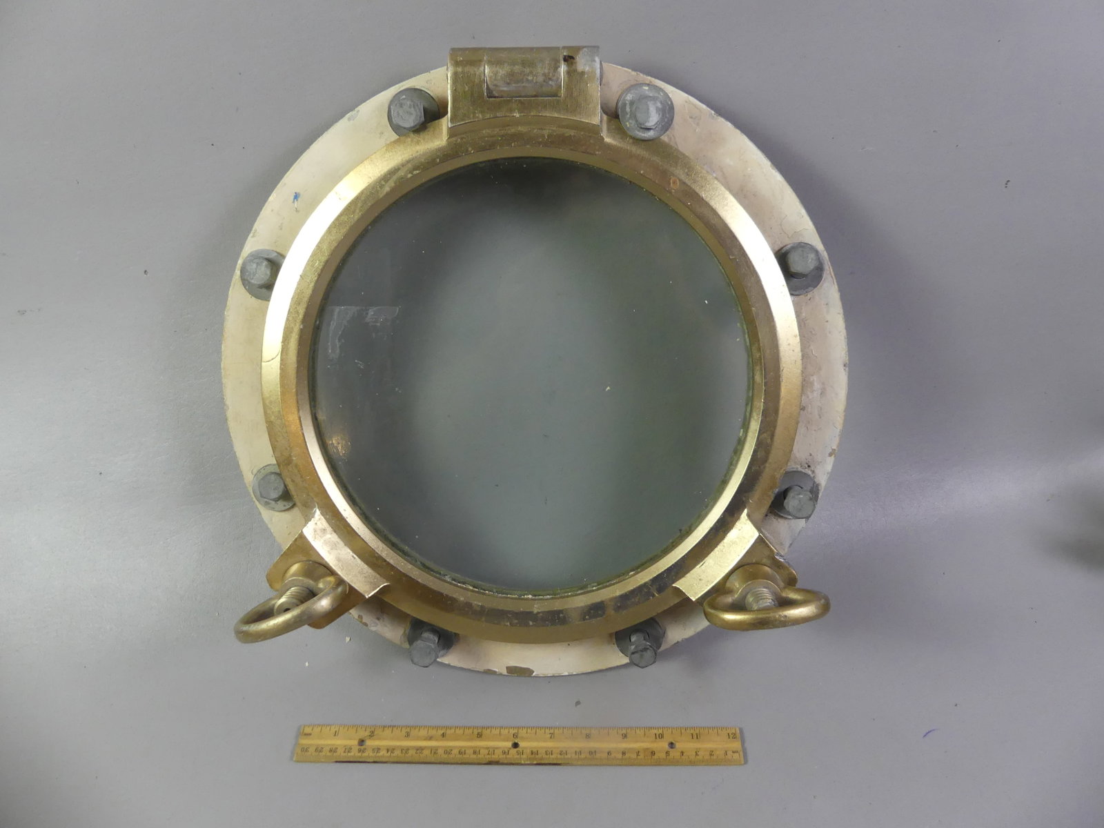 OLD SHIP PORTHOLE: Old metal ship or yacht porthole with bolts, glass is 12 in diameter, overall 17 in.