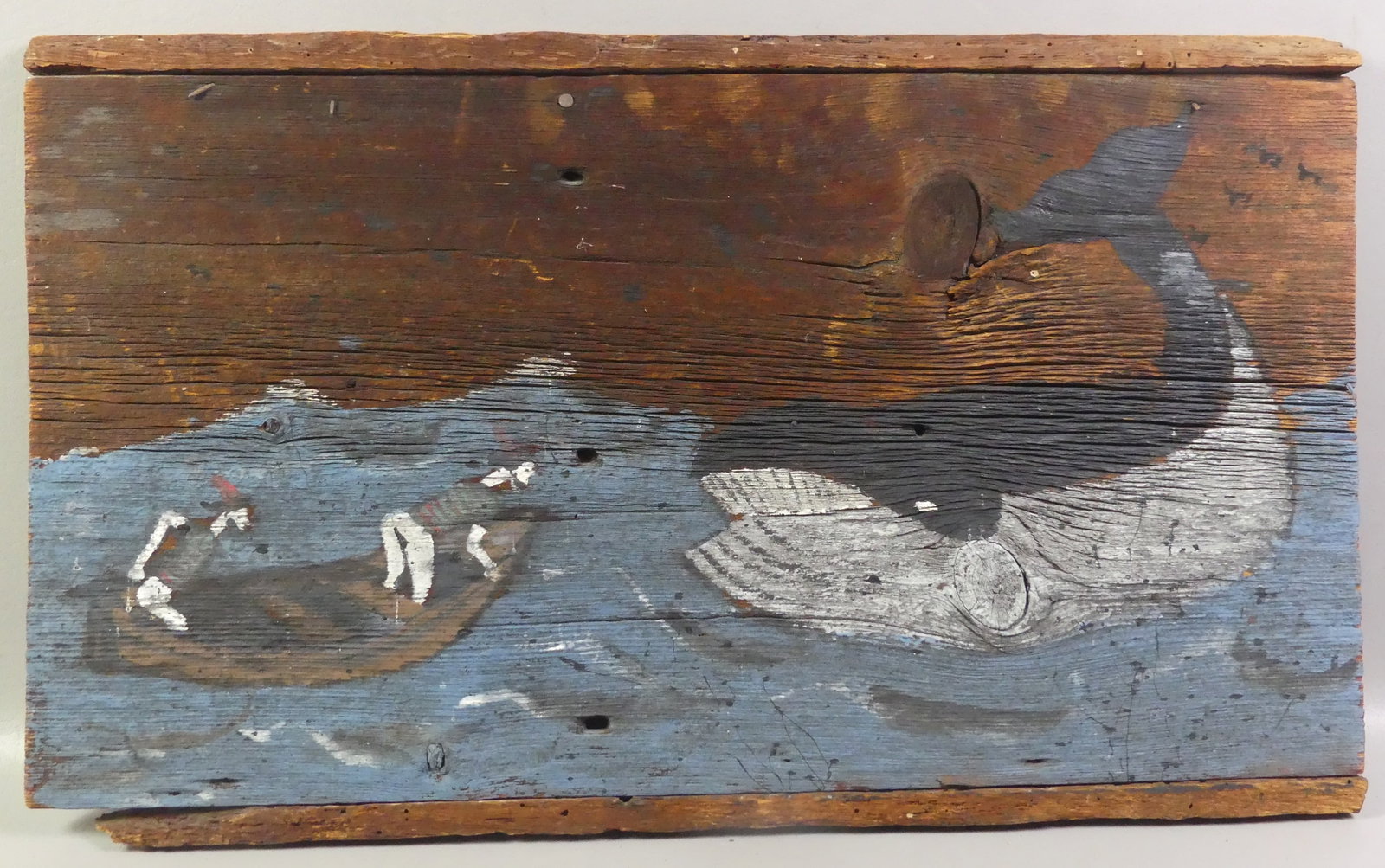 PAINTED WHALING SCENE PLAQUE: Vintage painted wood wall plaque with a whaling scene of 2 sailors in boat approaching a large sperm whale. 16 x 27.5 in.