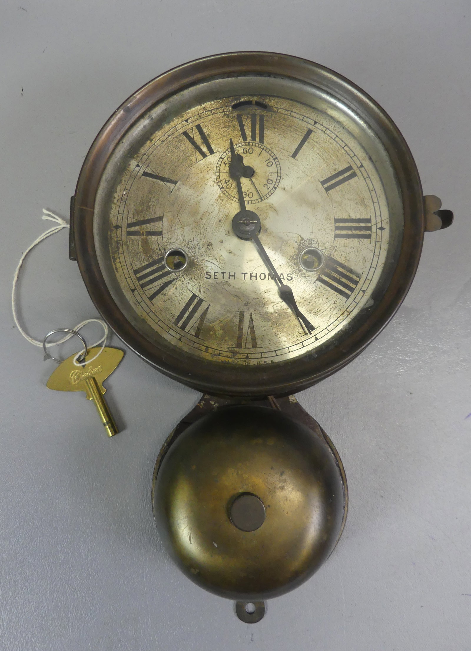 SETH THOMAS SHIP'S WALL CLOCK: 19th century Seth Thomas brass ship's wall clock with lower bell. Has time and strike with key. 11 in high, dial is 6 in diameter. Not currently running but winds ok.