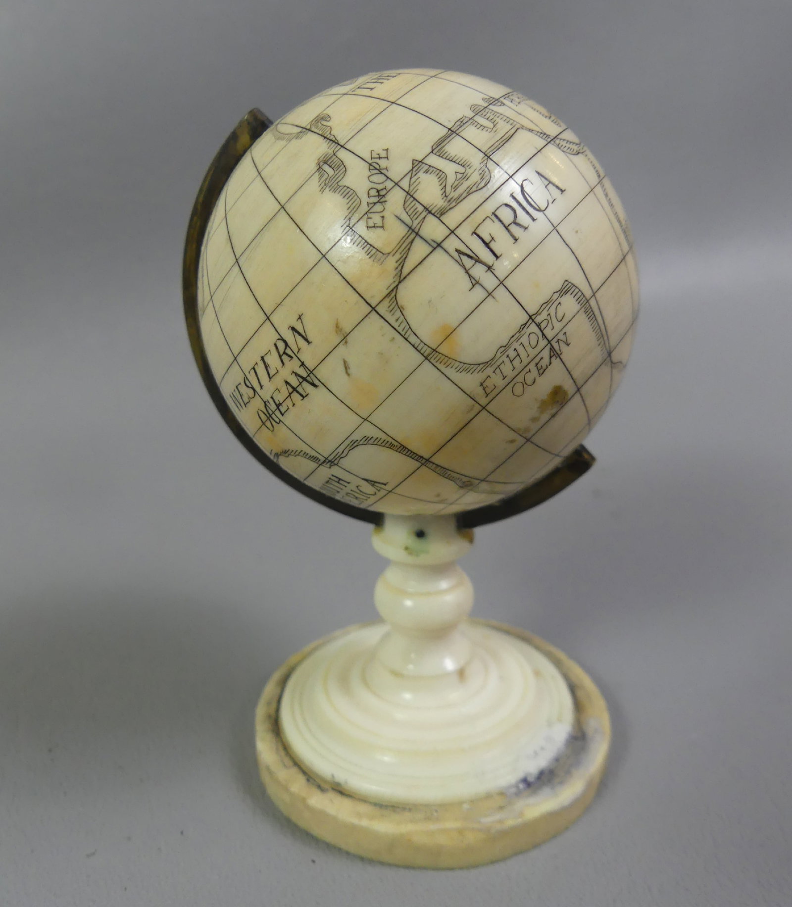 MINI SCRIMSHAW GLOBE OF THE EARTH: Old miniature organic scrimshaw globe of the earth on stand, 3.25 in high, sphere is 2 in diameter. VG condition.
