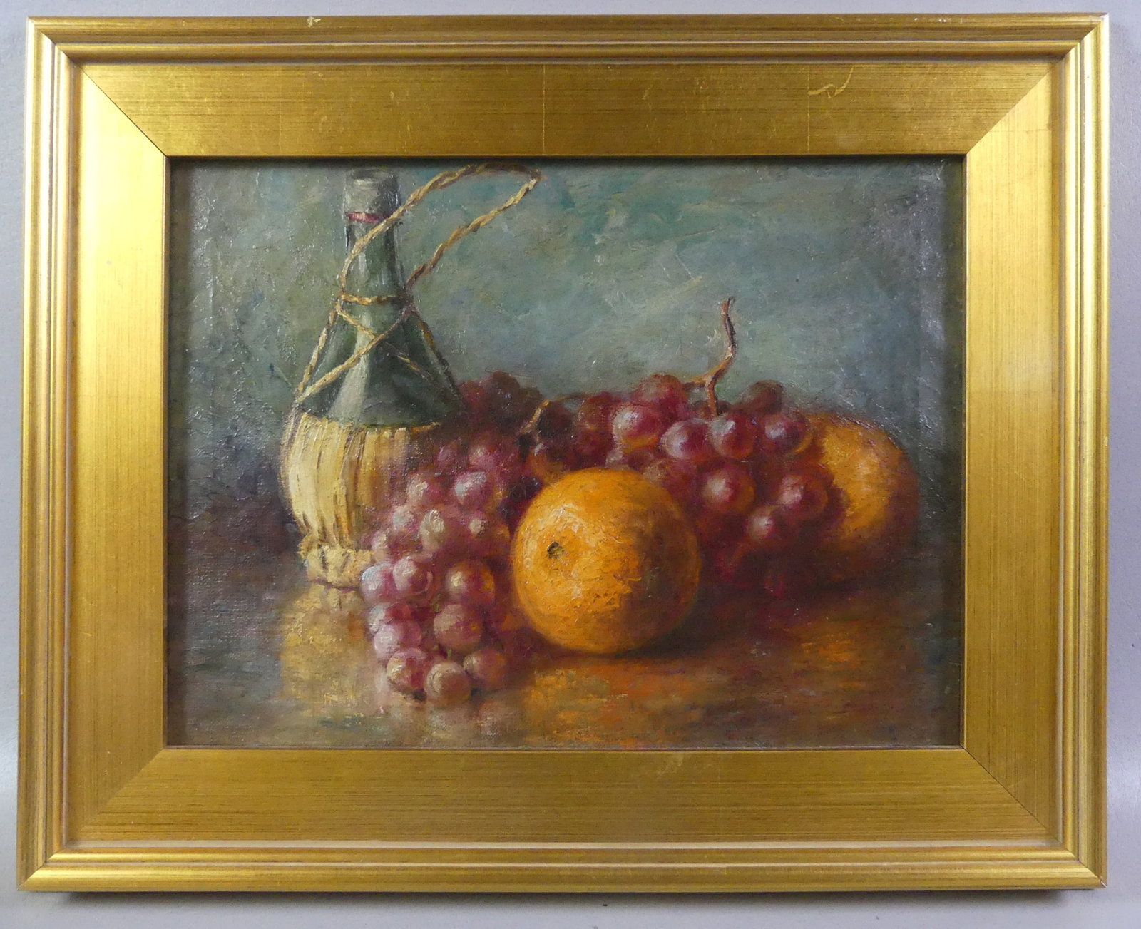 STILL LIFE PAINTING OF FRUIT: Unsigned old still life painting on canvas depicting a wine bottle, grapes and oranges. 12 x 16 in, framed 17 x 21.