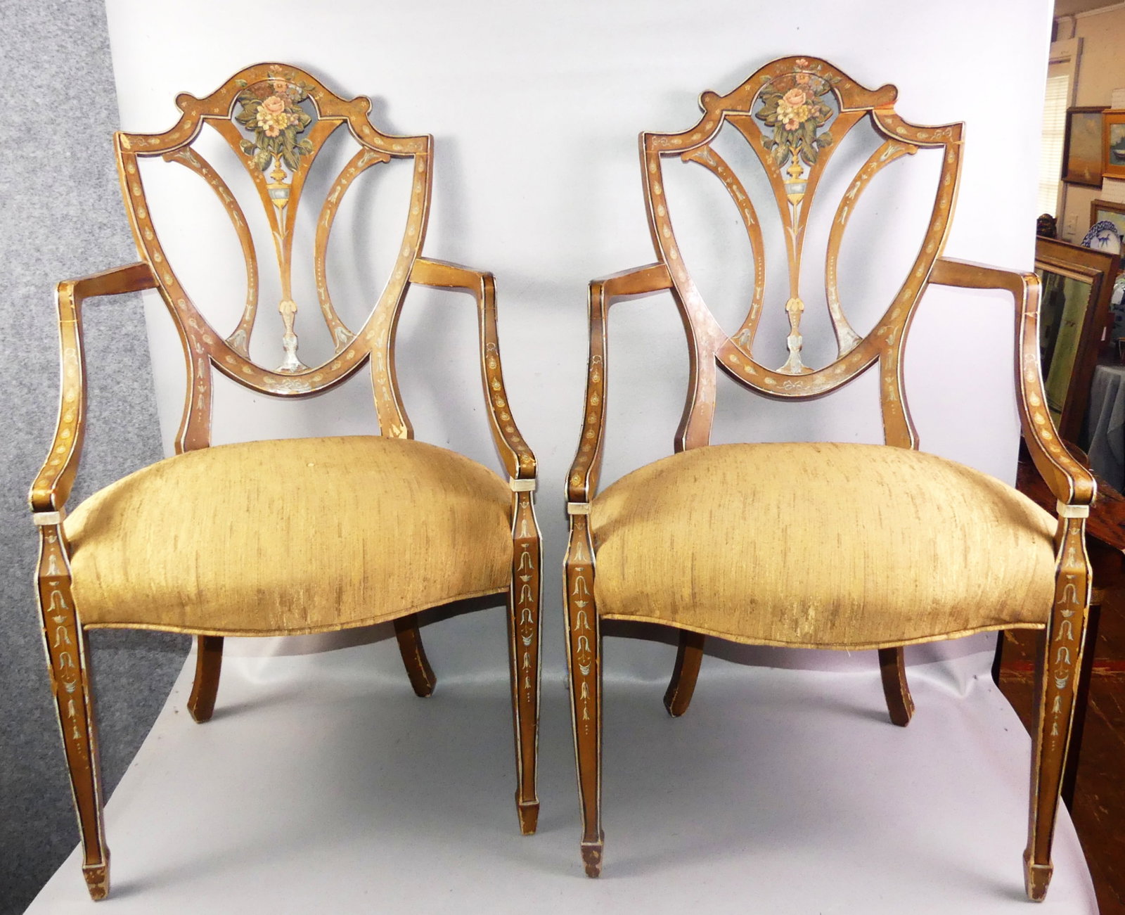 PAIR ADAMS STYLE ARMCHAIRS: Pair old Adams style painted Sheraton armchairs. One has chip out of back rail and both have some scattered wear to decoration. 40 in high x 22 w x 19 deep. Circa early 1900's.