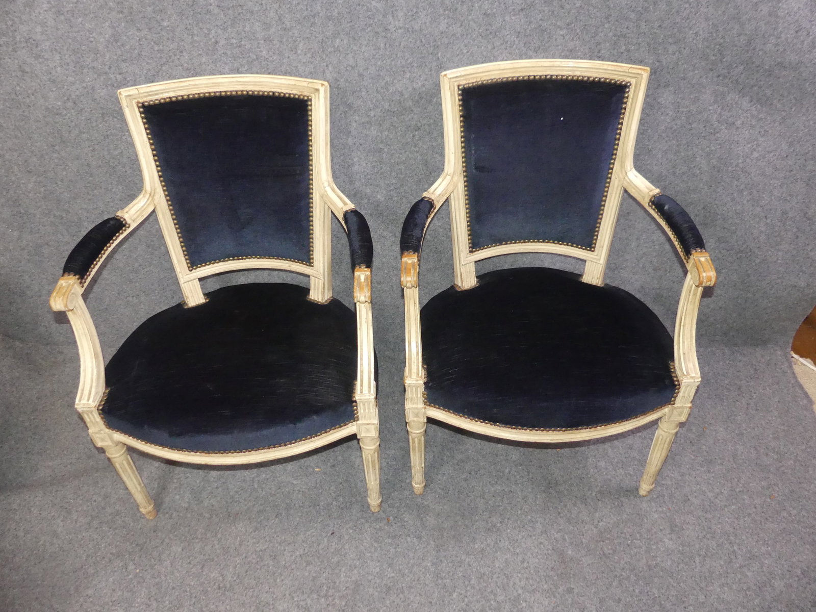 PAIR FRENCH PAINTED ARMCHAIRS: Pair Louis XVI carved and painted white armchairs with navy blue velvet upholstery. 33.5 in high x 23 w x 19 deep. Good condition.