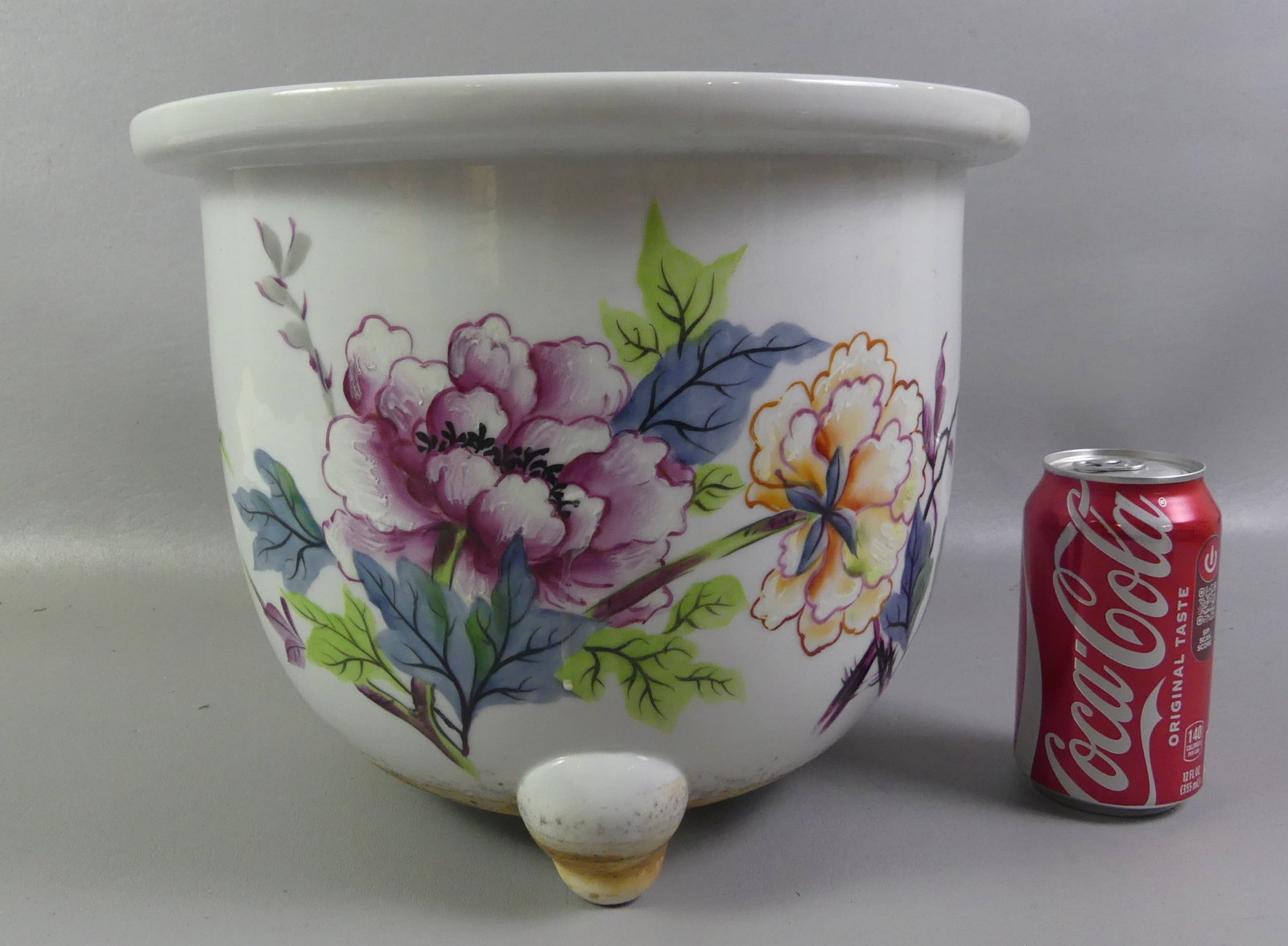 CHINESE FAMILLE ROSE JARDINIERE: Old Chinese famille rose jardiniere or planter with three feet, painted floral designs, birds, and script. Has red seal on underside. 9.5 in high and 12 in diameter.