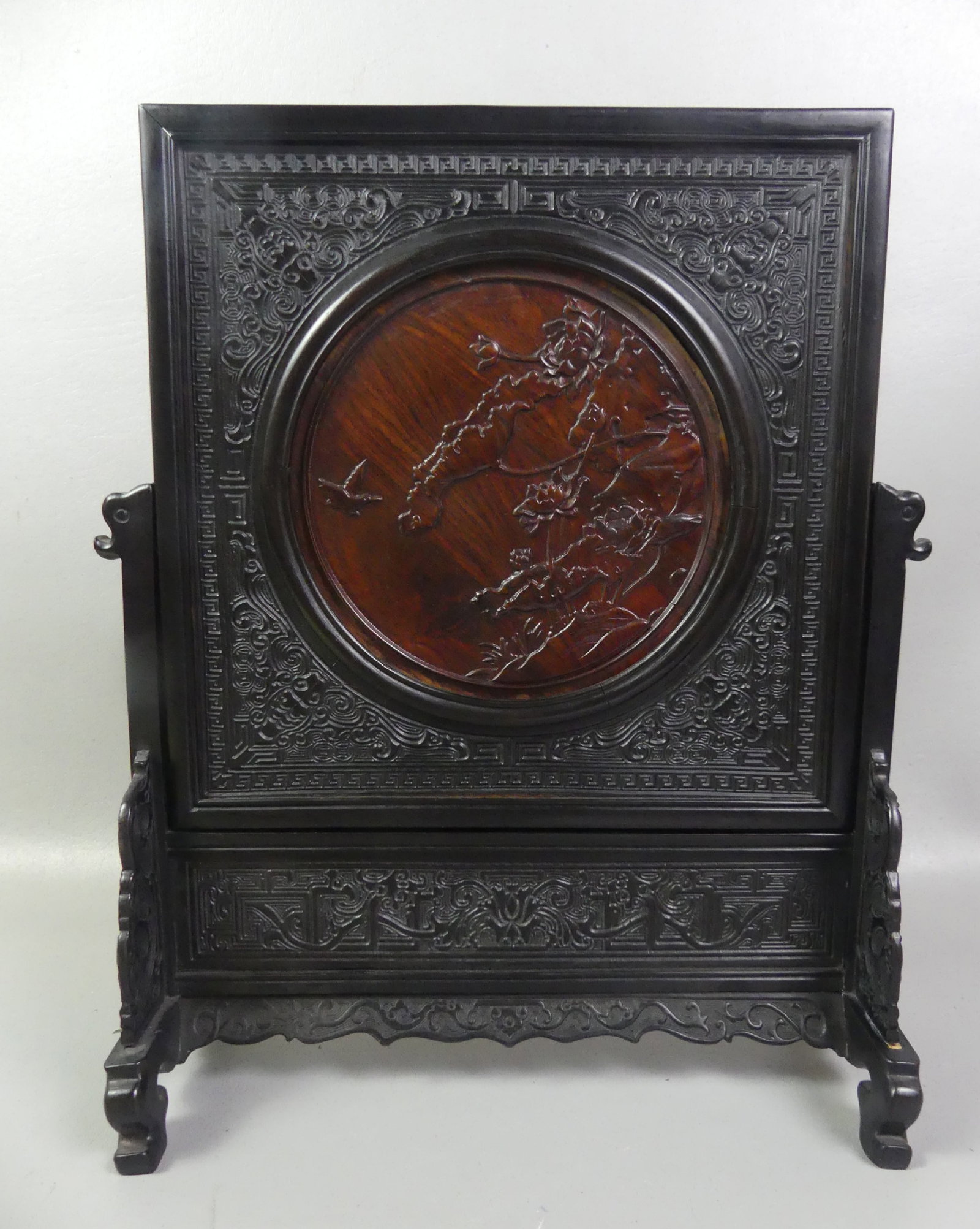 CHINESE HARDWOOD TABLE SCREEN - FLOWERS & SYMBOLS: Old 2 section Chinese hardwood table in onyx and rosewood with circular disc, flowers, and symbol meaning long life. 16.5 x 13 x 5 in deep.