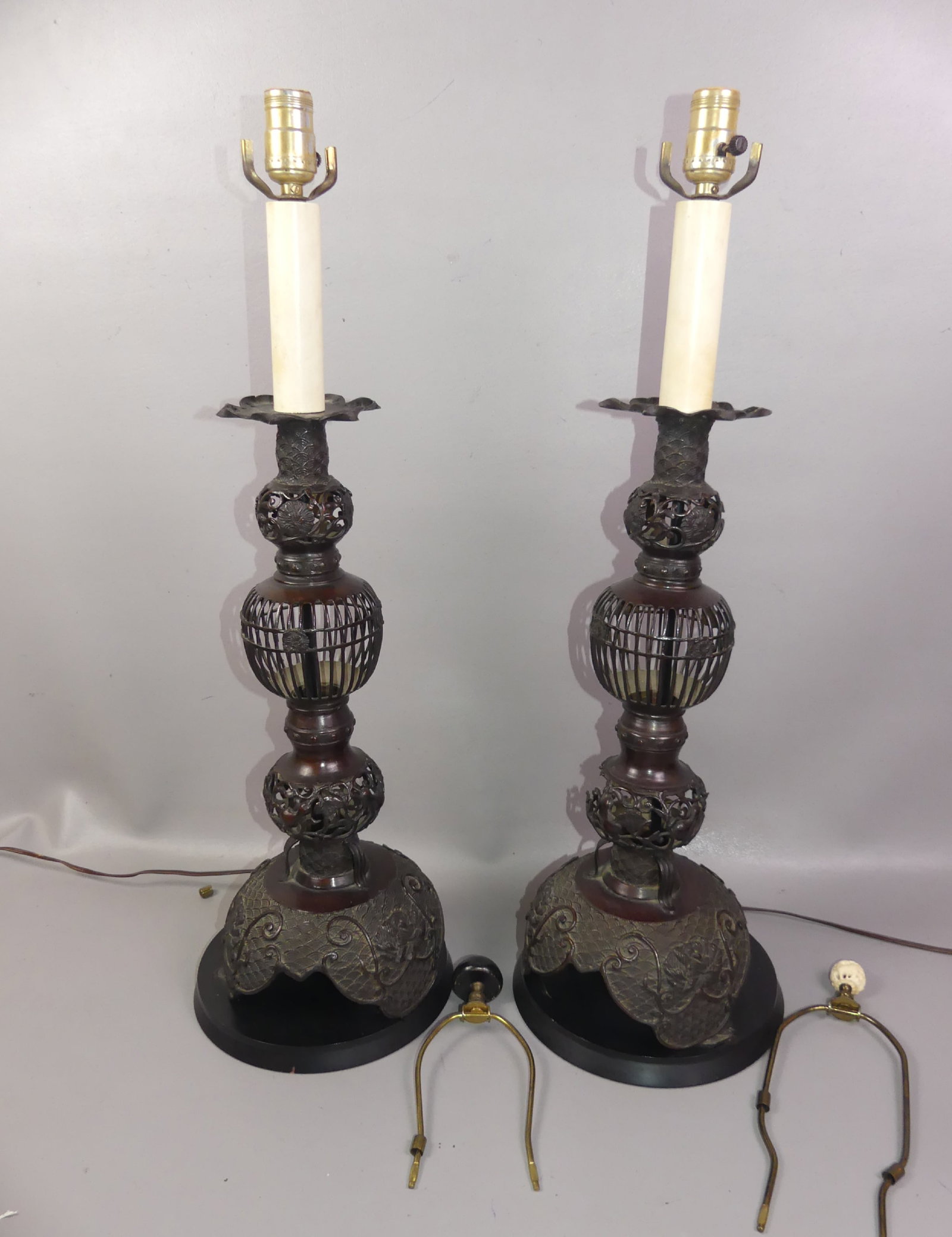 PR. ASIAN BRONZE 20 INCH CANDLESTICKS: Pair of antique Asian bronze reticulated tall candlesticks modified as electric lamps, may have been Buddhist altar candlesticks. 37 in tall to top of harps, base is 20 in. Loss to one section on lamp