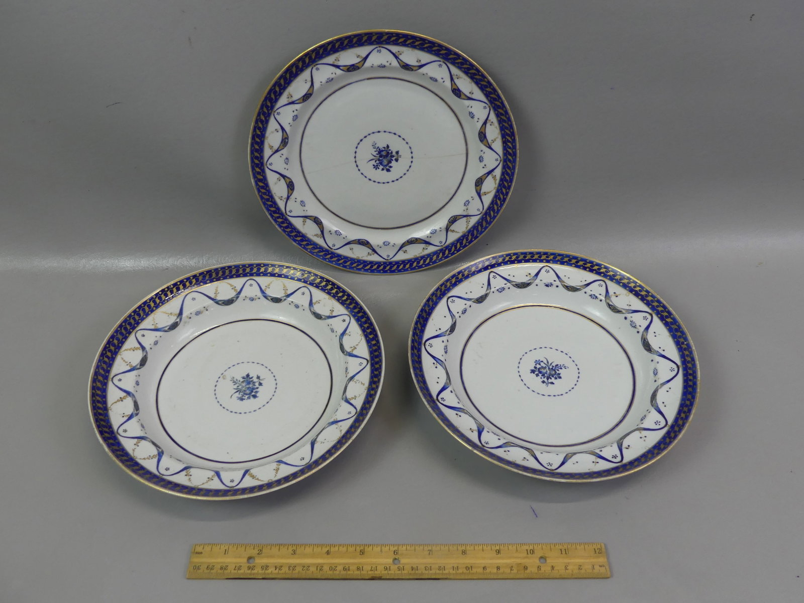 3 CHINESE QIANLONG COBALT PLATES: Set 3 Chinese Export 18th century Qianlong ceramic plates with blue ribbon swags, stars and floral center with fine gilding: Pair of 9.75 in shallow bowls/plates (both VG); and 9.75 in plate (ageline)