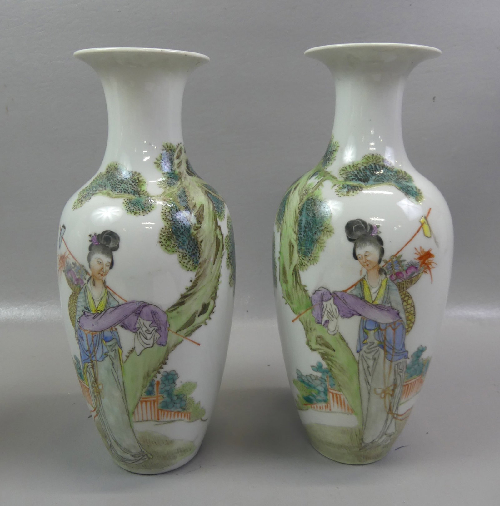 PAIR CHINESE FAMILLE ROSE VASES - SIGNED: Pair of old Chinese Famille Rose white porcelain vases with red seal (Republic period) depicting women carrying long stick and sack of fruit. 11 in tall. Both VG condition.