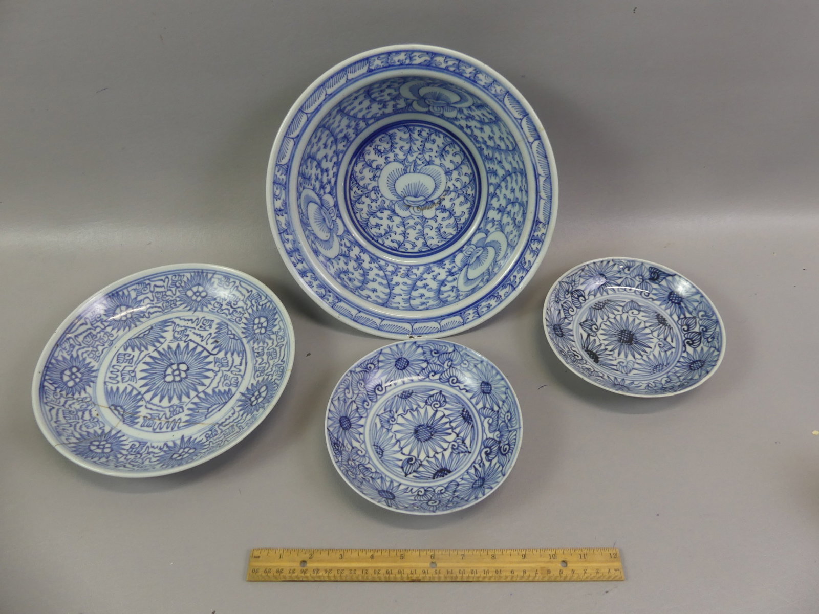 4 ANTIQUE CHINESE BLUE & WHITE BOWLS: Lot of four 19th century Chinese blue and white bowls with allover floral designs: 11.5 x 4 in deep bowl or basin with wide lip (3 in hairline); Pair 7 in signed shallow bowls (1 perfect, 1 has rim