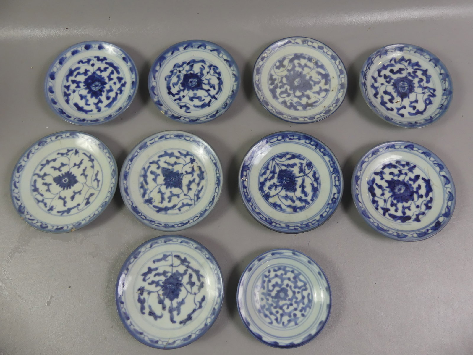 10 ANTIQUE CHINESE BLUE PLATES - SIGNED: Group of ten 19th century Chinese blue and white floral decorated small plates, all signed. From 5-6 in diameter. Five have an ageline, one with 2 small rim chips.