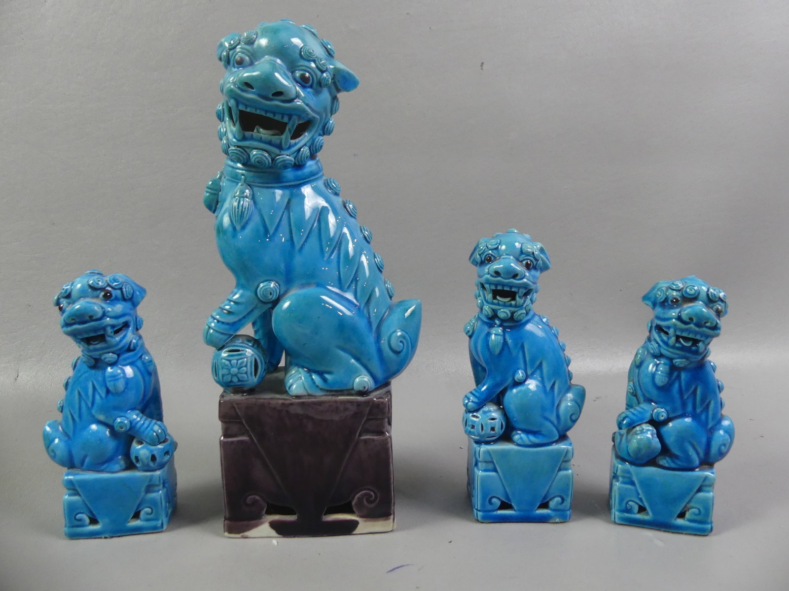 4 CHINESE BLUE POTTERY FOO LIONS: Group of 4 blue glazed Chinese pottery foo lions on pedestals from 4.5 to 9.5 in tall. All VG condition.