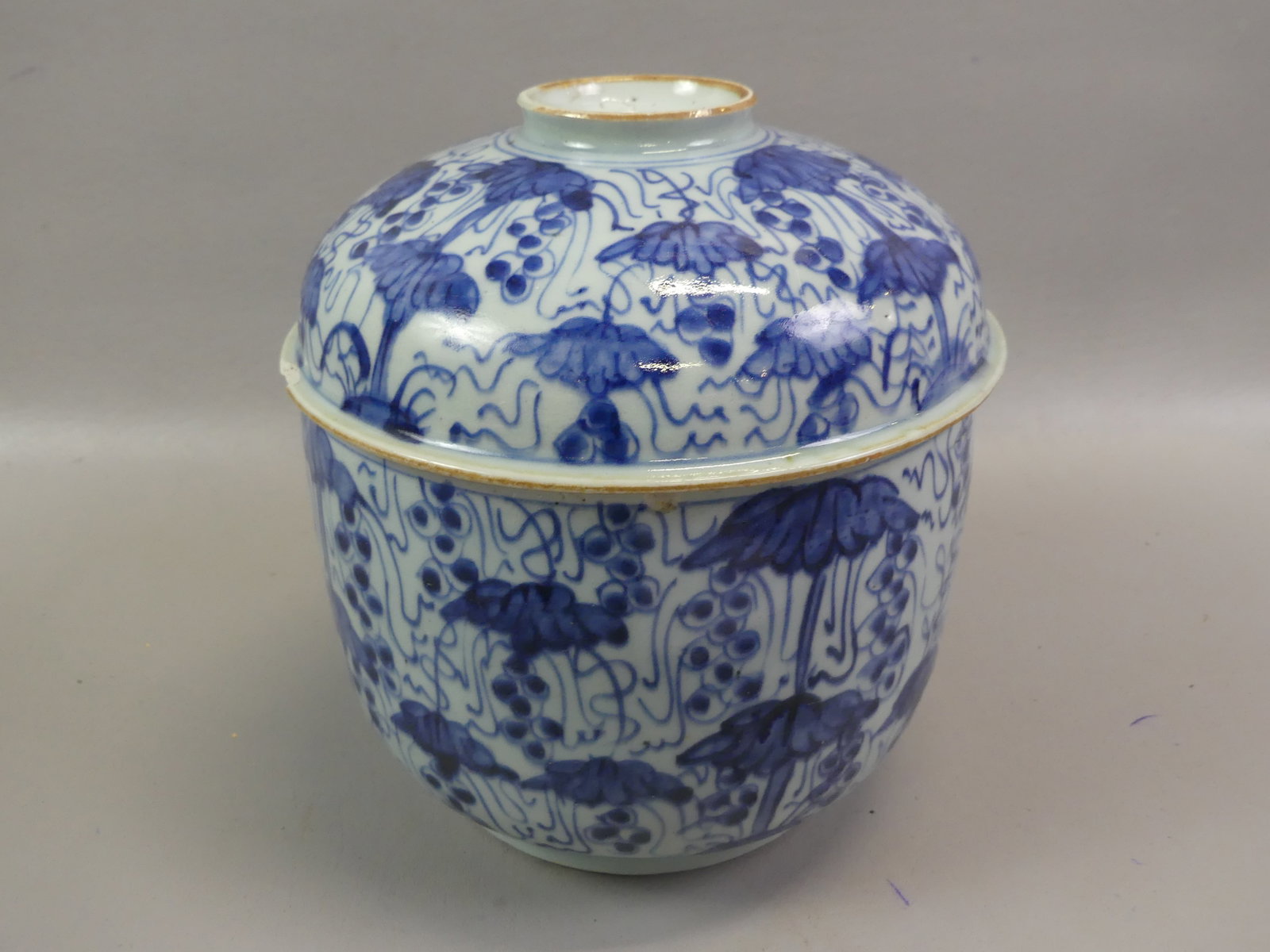 ANTIQUE CHINESE BLUE & WHITE COVERED JAR: Antique Chinese round covered large jar (potiche) with lotus and berry decoration. 7.5 x 8.5 in high. Has 2 rim chips on cover and internal ageline. Circa 18th/early 19th century.