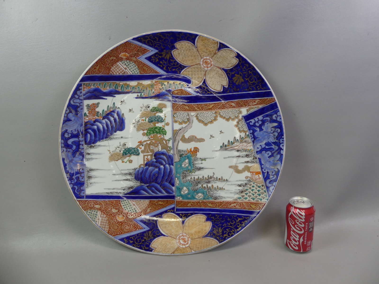 LARGE JAPANESE IMARI CHARGER: Very large Japanese Meiji period Imari charger with scenic designs, 21.5 in diameter, unsigned. Has professionally repaired cracks.