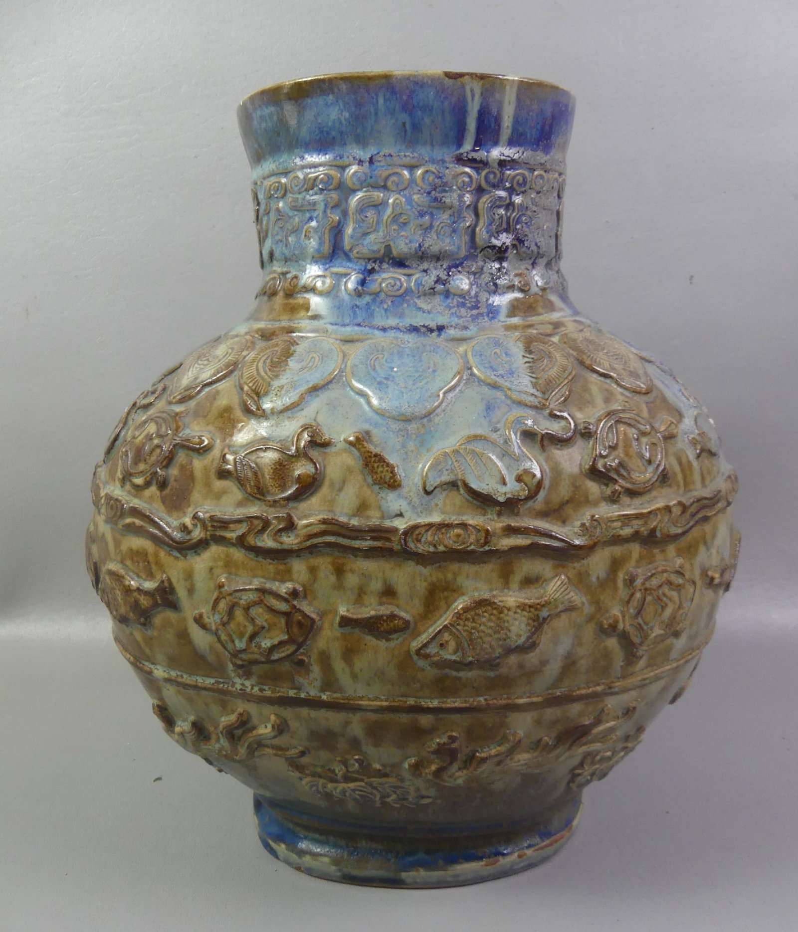 EGYPTIAN STYLE ART POTTERY VASE: Unusual old blue and brown glazed ceramic vase with embossed animals including fish, ducks, turtles, etc. Underside has impressed Egyptian style mark. Size: @ Good condition.