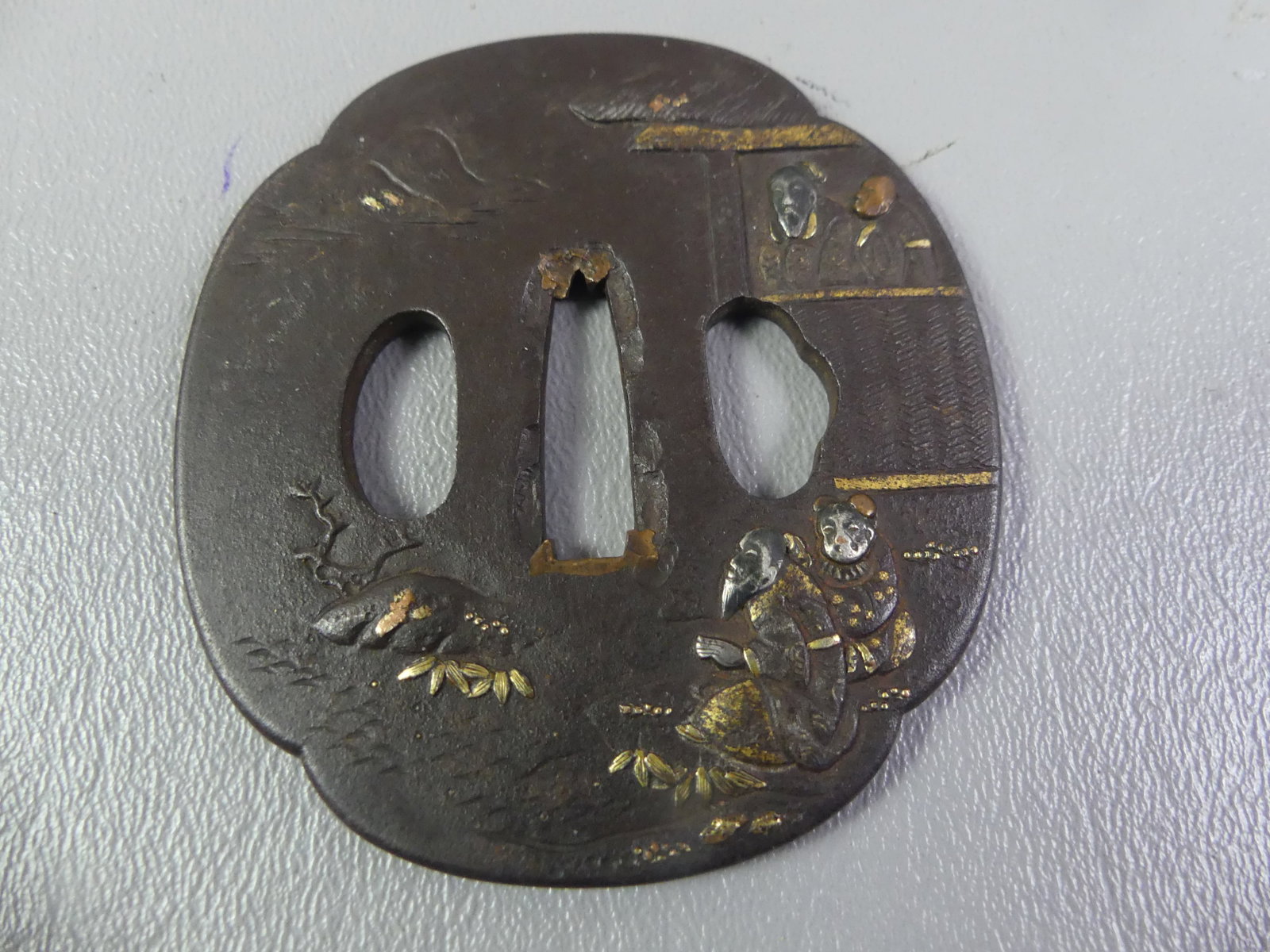 ANTIQUE BRONZE TSUBA - 4 FIGURES: Edo period Japanese iron tsuba with mixed metal inlay (shakudo) of 4 figures, back has a landscape scene. Unsigned. 3 x 2.75 inches.