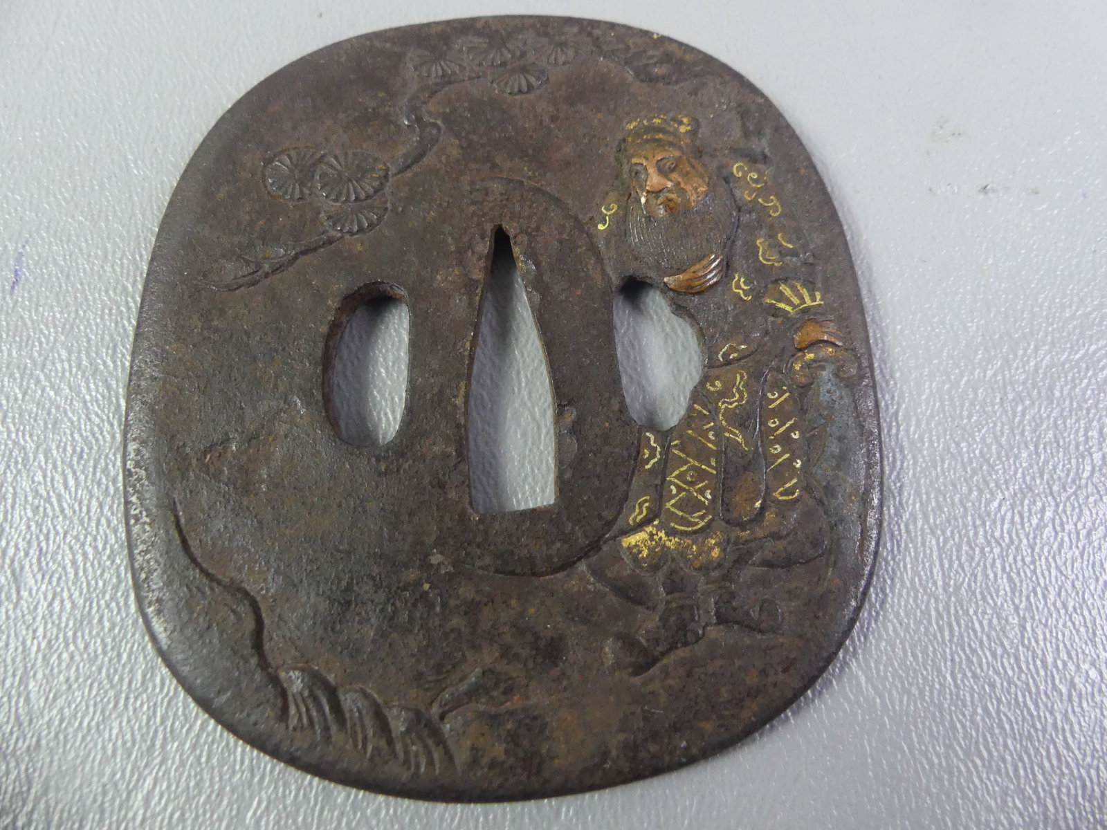 ANTIQUE IRON TSUBA - WARRIOR: Edo period Japanese iron tsuba with mixed metal inlay (shakudo) of a warrior in landscape. Unsigned. 3 x 2.5 inches.