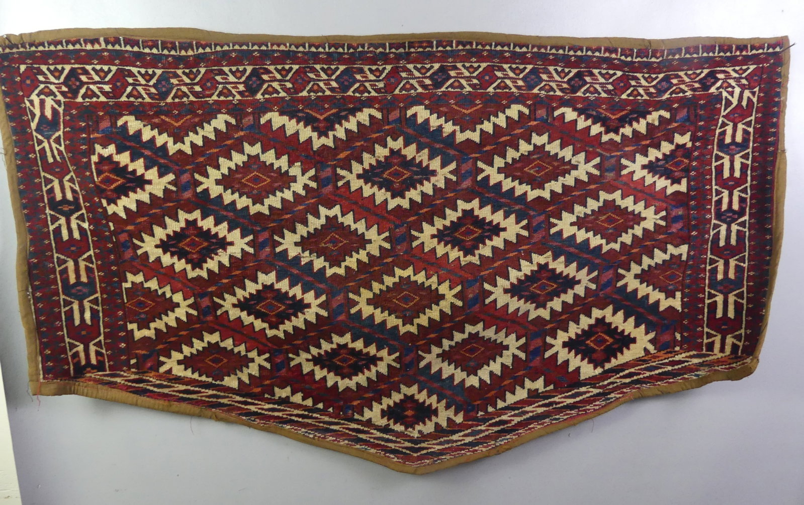 ANTIQUE YOMUT ASMALYK CAMEL TRAPPING: Antique Yomut Tukoman Asmalyk camel trapping rug with bound edges, 3 ft 10 x 2 ft 2 inches. Good condition.