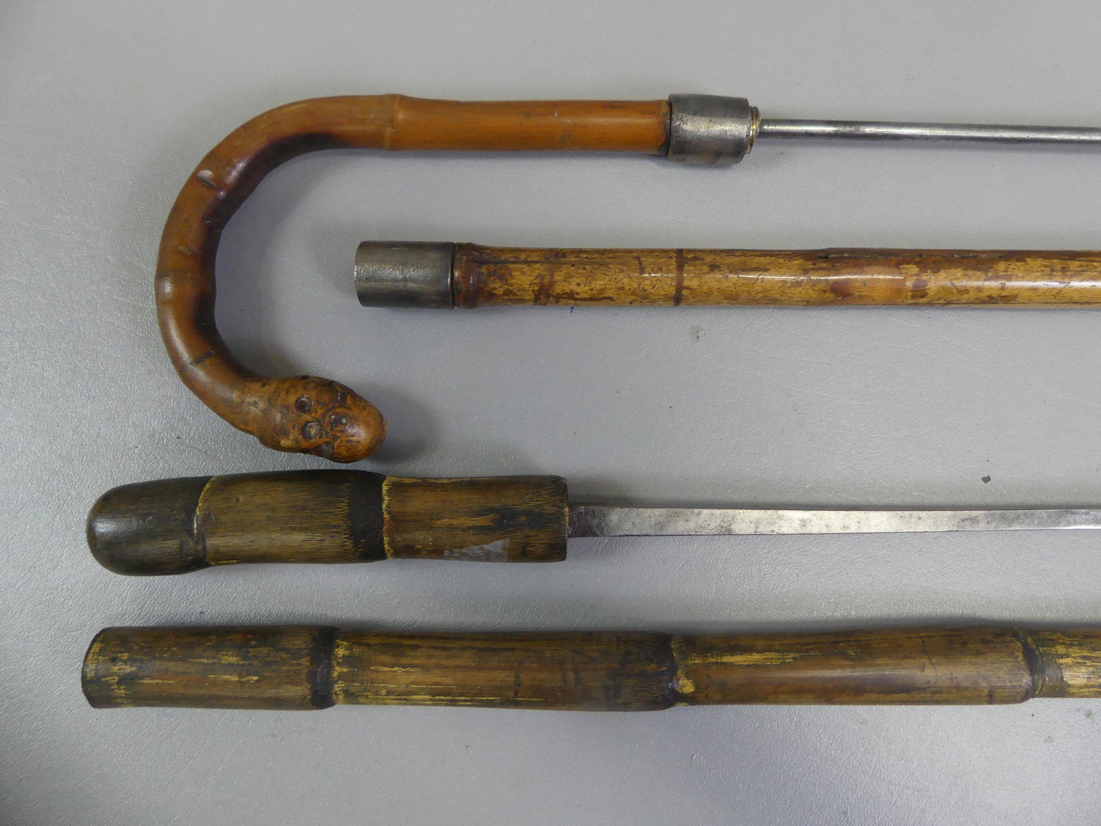 2 RUSTIC SWORD CANES: Lot of 2 antique rustic sword canes to 35 in long: Square steel blade, 28.5 in; and 22 in round screw-on dagger with bamboo shaft and shepherd hook handle.