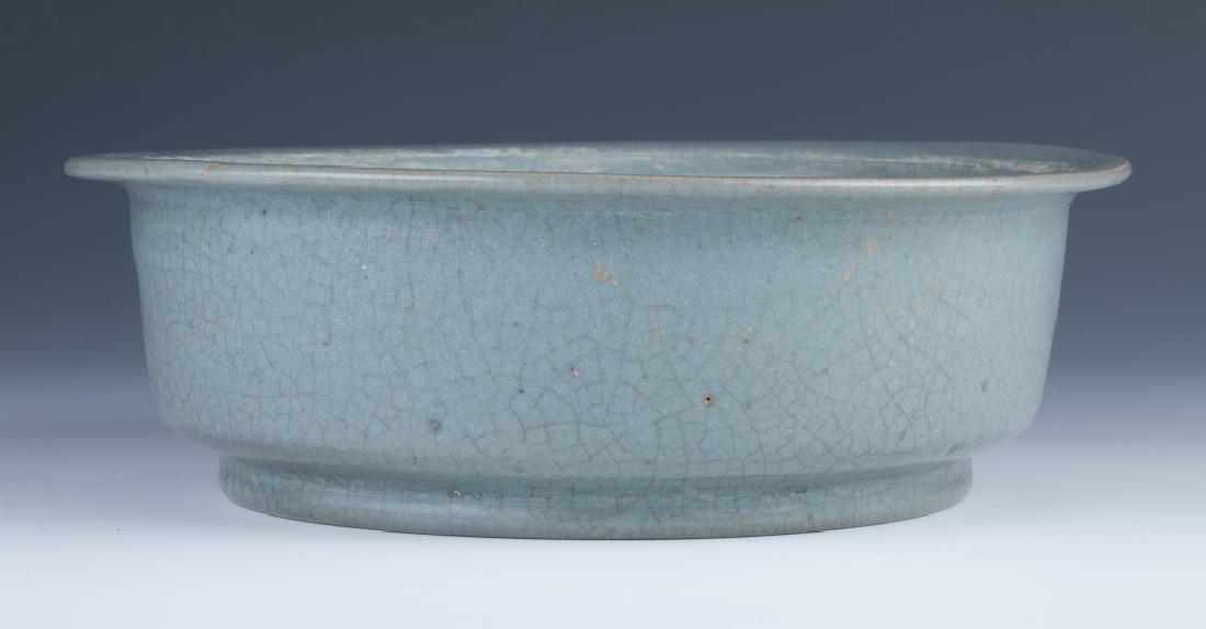 A Ruyao Water Sand Washer: A ruyao water sand washer, overall applied in light-blue glaze, suffused with network of dark crackles, diameter 22 cm
