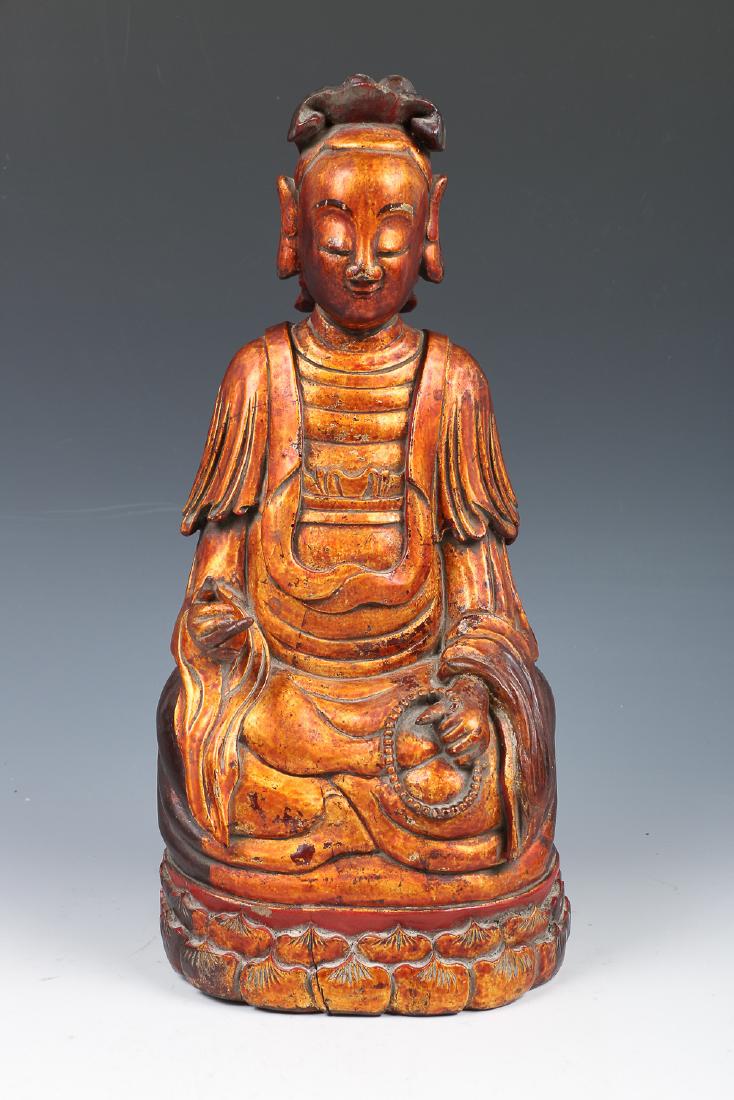 GILT-LACQUERED BUDDHA FIGURE: Seated Buddha with detachable right hand curling the second and third finger, left hand holding beads, dressed in a long robe tied under the chest and covering the shoulders, the face a meditative exp
