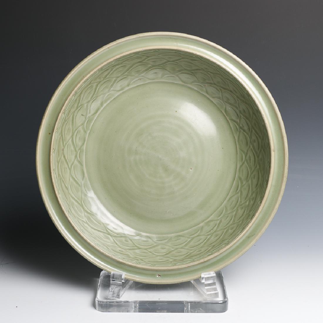 LONGQUAN BOWL MING: Of ovoid body with double everted rim, the interior carved with wave patterned and a chevron patterned band close to the inner rim, all covered in celadon glaze. D:41.3, H:8.5cm