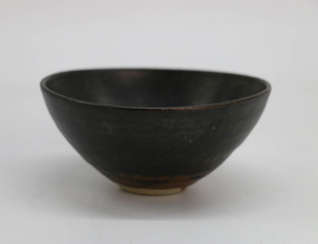 A JIZHOU YAO LEAF BOWL BEFORE YUAN: potted with curved conical sides rising from a short tapering foot, covered overall in a thick lustrous black glaze, the interior painted a leaf pattern in brown and white color. D:12cm