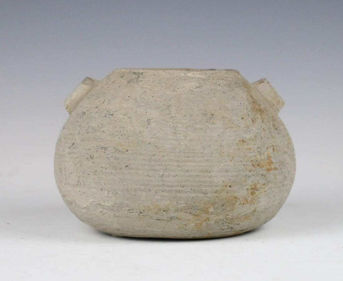 A DOUBLE EAR POTTERY JAR BEFORE CENTURY: of broad rounded form with twin tubular handles and slightly everted rim, overall in light grey color. H: 11cm
