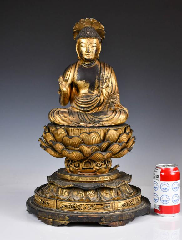 A Japanese Lacquer-Gilt Wood Carved Buddha: Seated in vajrasana on a double loti form base in front of a vajra,sitting cross-legged in padmasana, depicted with the right hand in Abhaya mudra and the left hand gently resting on the left thigh in