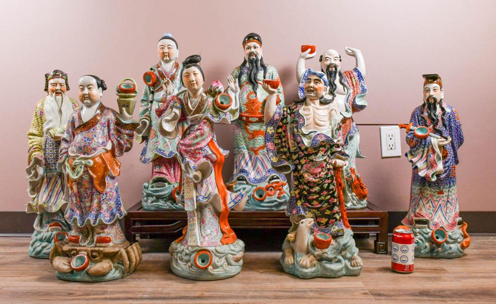 A Set Chinese Figures of the Eight Immortals: Each figure in a standing position wearing brightly colored robes on the back of a different animal or mythical beast in waves, H: 60-65cm 20世紀 粉彩八仙立&#