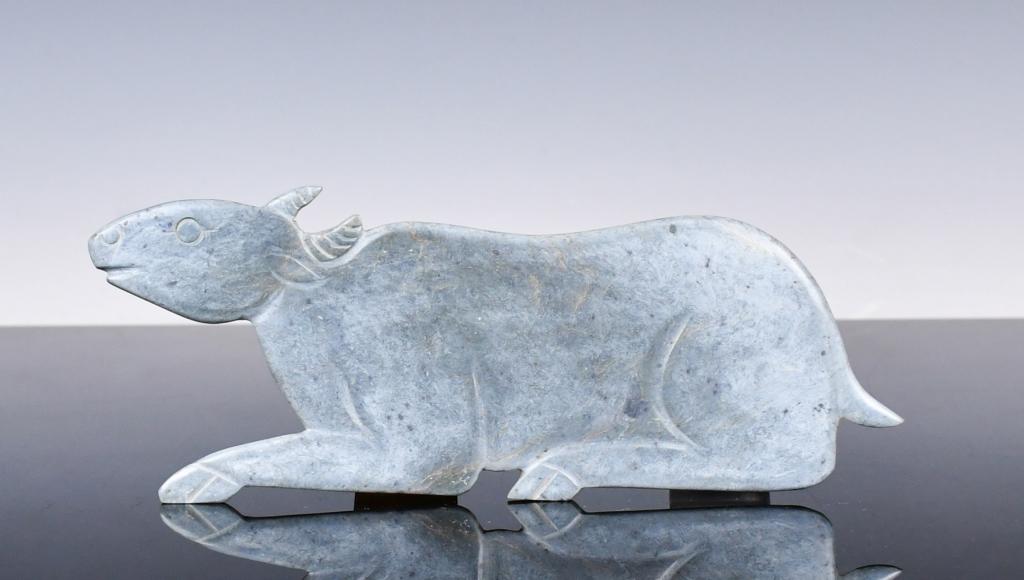 An Archaic Jade Ox Zhou Dynasty Style: An archaic green jade ox in a crouching position, L: 20cm, H: 7.5cm 周風格 玉牛擺件 來源：古今閣 Condition report upon req