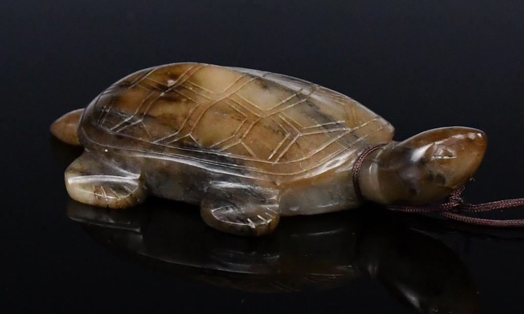 A Turtle Shape Jade Carving: Carved in a turtle shape, the head and eyes straightly facing the front, in greyish celadon and russet tones. L:9.5cm 龜型玉擺件 來源：古今&