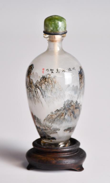 An Insided-Painted Snuff Bottle Hongsheng Mk 20thC: Of a narrowed neck to a bulged shoulder tapered down to a flat base, inside-painted a view of landscape, and inscribed the author's signature. H: 8.5cm 20世紀 內玻璃Ĭ