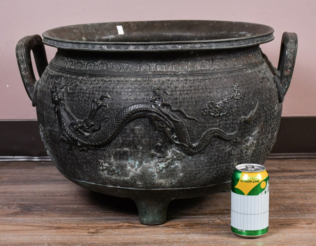 A Large Double-Ear Tripod Incense Burner, 19thC: The globular body is set on top of three sprayed feet, flanked to the shoulders with a pair of upward looped ears, carved to the exterior with a dragon scene. D: 54 x H: 34cm 19世紀 ༕