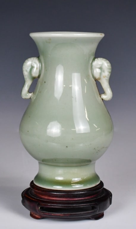 A Celadon Glaze Elephant Handled Vase w/Std 19thC: Of baluster form, the waisted neck flanked by a pair of elephant head handles, H: 15.3cm. Comes with a wood stand. Provenance: Vancouver HongKong Immigration 19世紀 青釉雙
