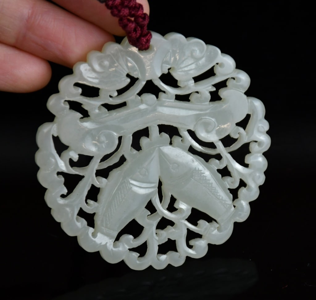 A Reticulated Jade Plaque Qing: Of round shape, the reticulated jade plaque depicted fish and bat among scrolling leave, D: 5.7cm 清 透雕吉慶有餘玉牌